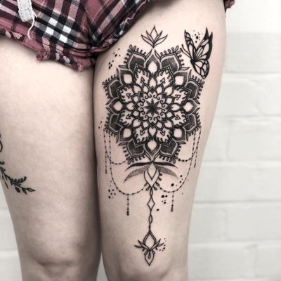  Tatouage mandala avec un papillon sur le devant de la cuisse